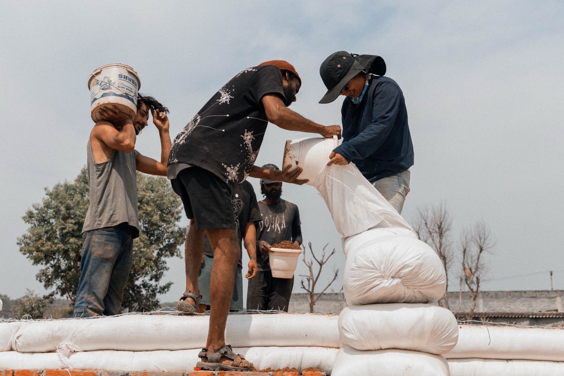 Filling earthbags for the walls