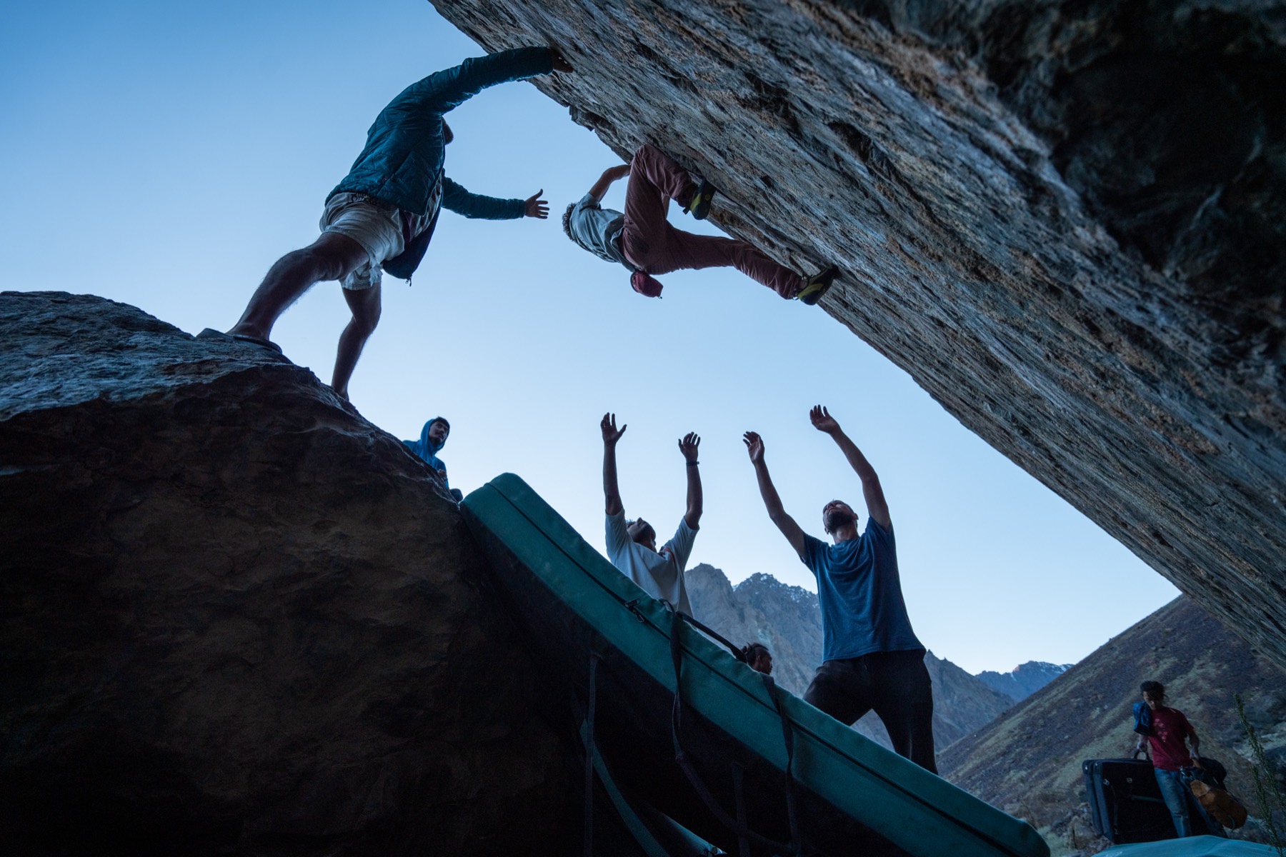 Topping out a boulder as friends cheer